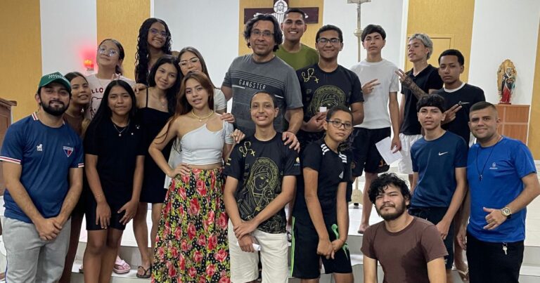 Grupo de jovens e adultos reunido no interior da Comunidade Nossa Senhora do Perpétuo Socorro durante encontro sobre juventude e vocação, promovido com a participação do Centro MAGIS Amazônia.