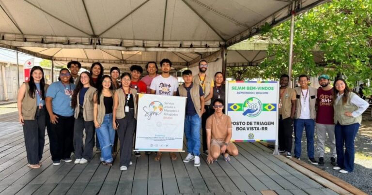 Grupo de jovens e colaboradores posa para foto durante visita ao Posto de Triagem de Boa Vista (RR), junto à equipe do Serviço Jesuíta a Migrantes e Refugiados (SJMR).