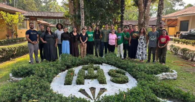 Participantes do retiro de Exercícios Espirituais para Jovens, promovido pelo Centro MAGIS Amazônia, reunidos para foto em um jardim da Casa de Retiros Ir. Vicente Cañas, em Manaus (AM), com árvores, jardins e construções ao fundo.
